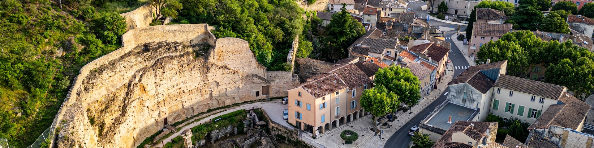 An ancient stone bridge, a town with historic buildings, and a lush green hillside.