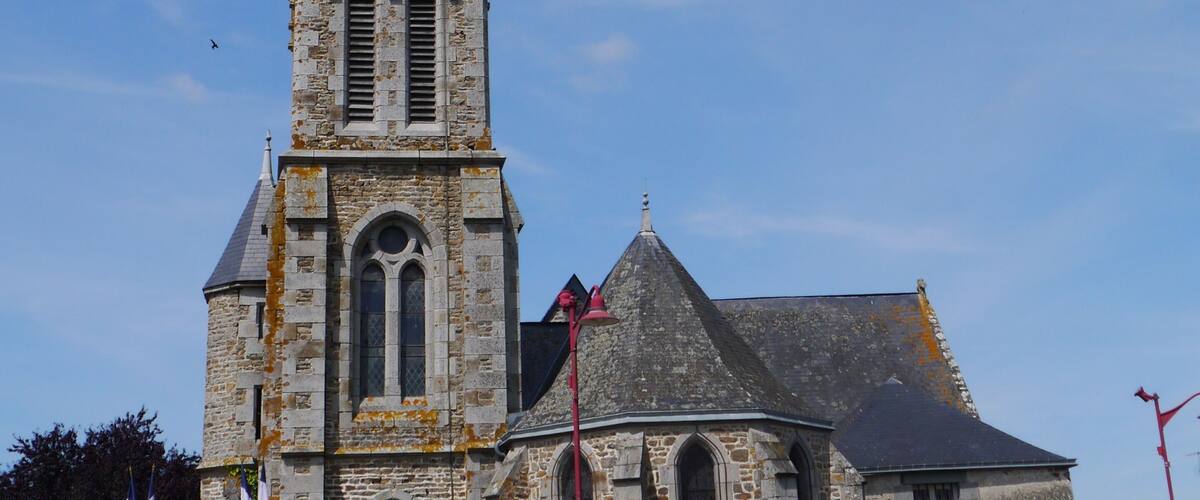 A stone church with a tall steeple and a weather vane.