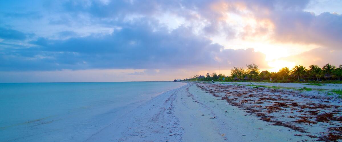 Isla Holbox which includes a sunset, a sandy beach and landscape views