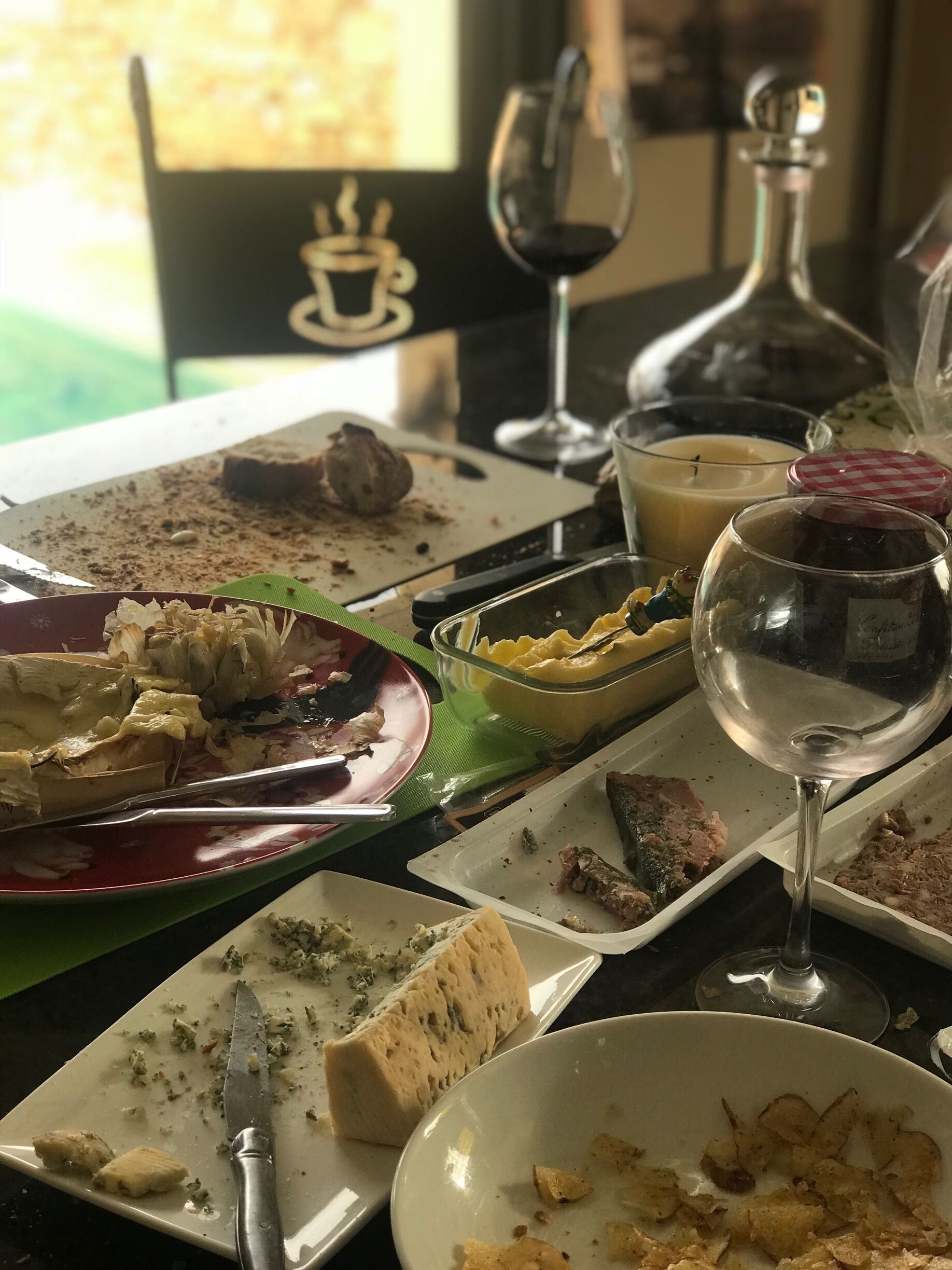 A table with various dishes, a wine glass, and a candle.