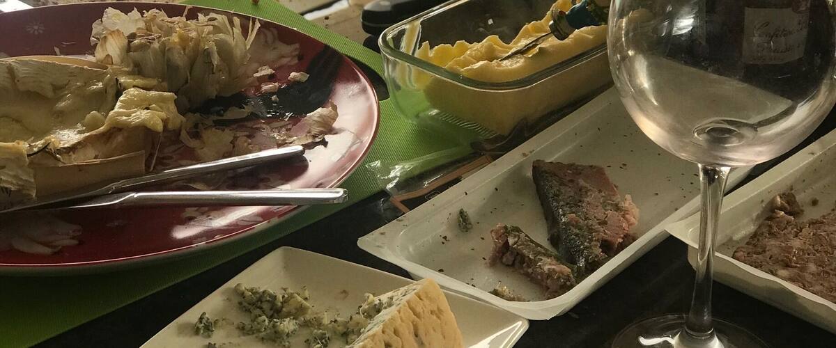 A table with various dishes, a wine glass, and a candle.