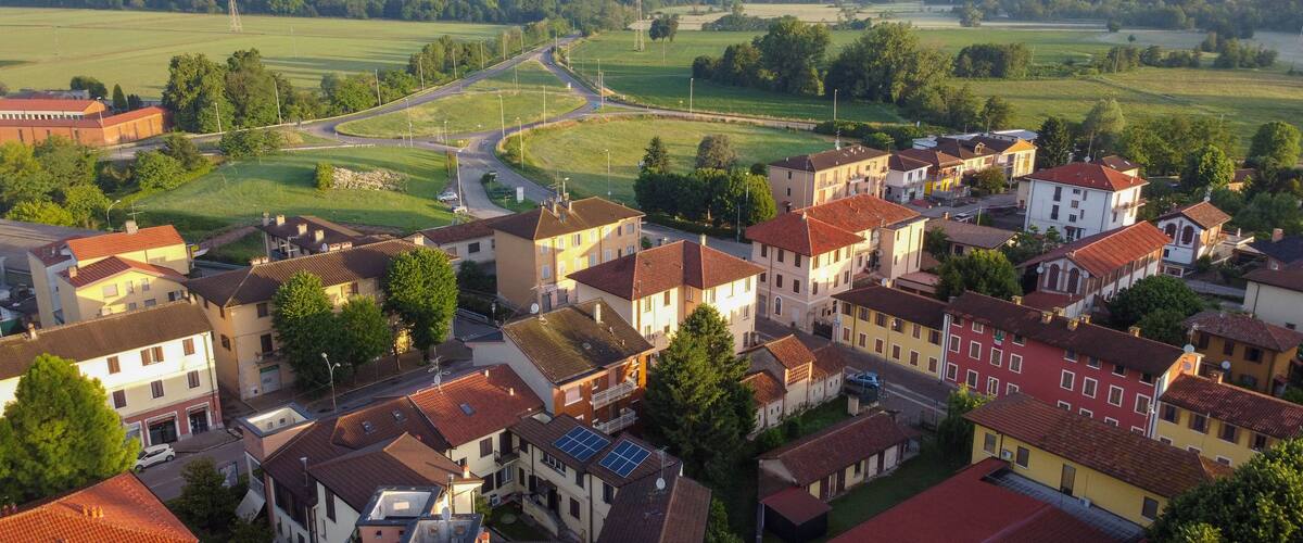 A residential area with houses, roads, and green fields.