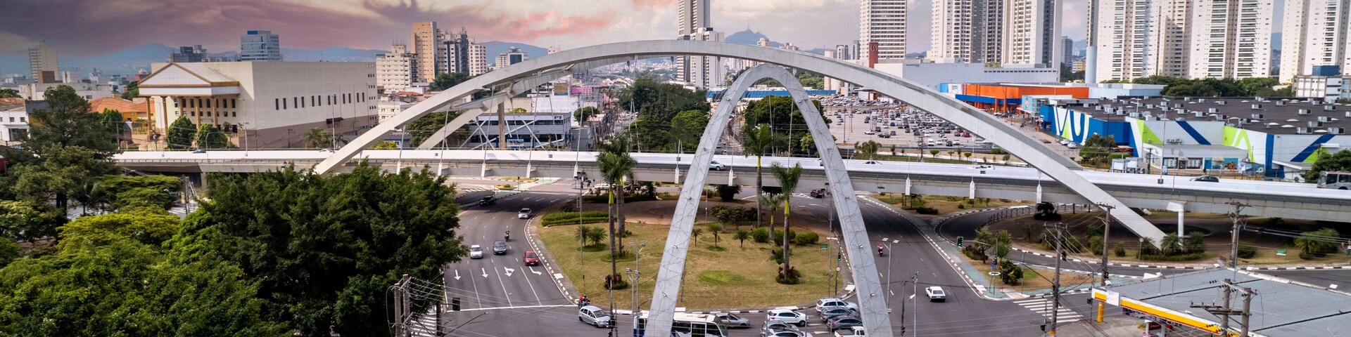 Un paisaje urbano con un puente arqueado destacado, edificios altos y una glorieta.