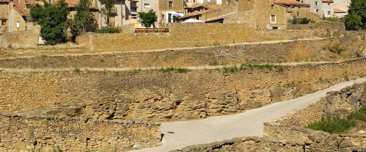 A rural village with stone buildings and terraced fields.