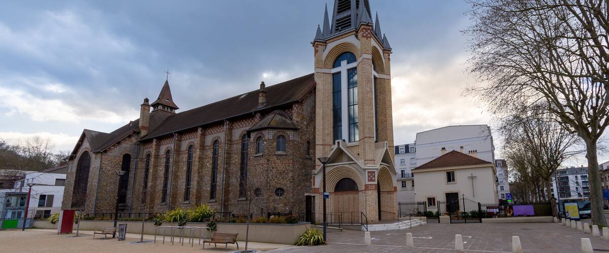 A historic church with a tall spire and arched windows.