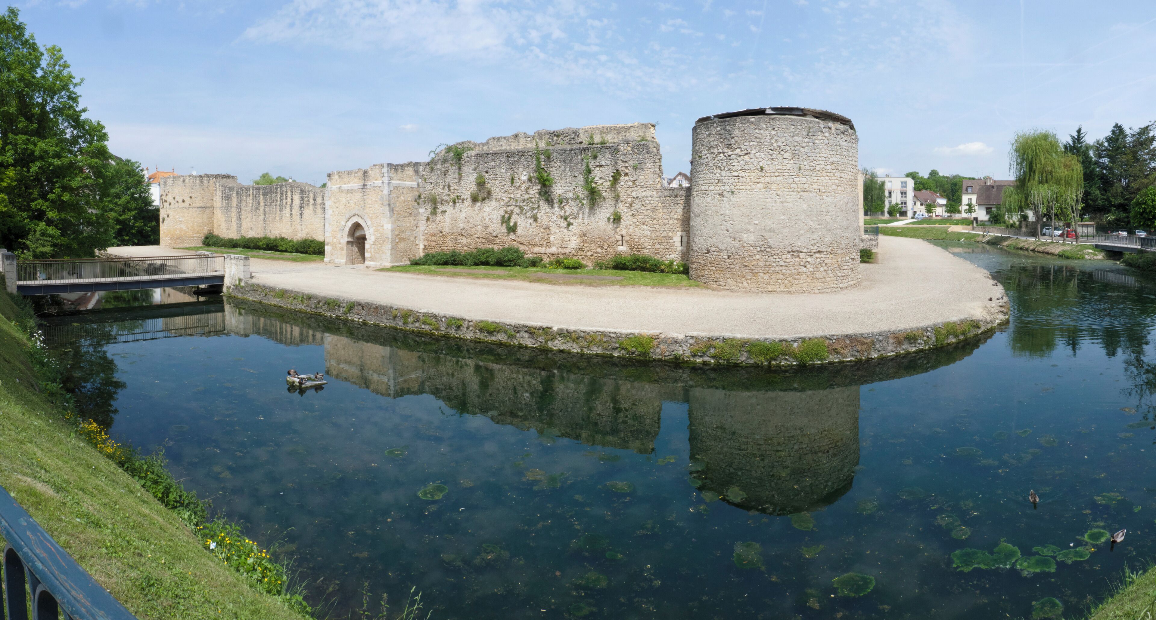 A historic stone castle with a moat and a bridge.