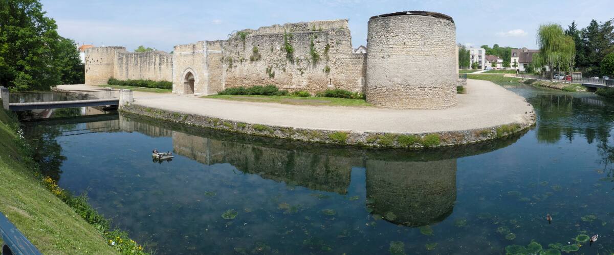 A historic stone castle with a moat and a bridge.