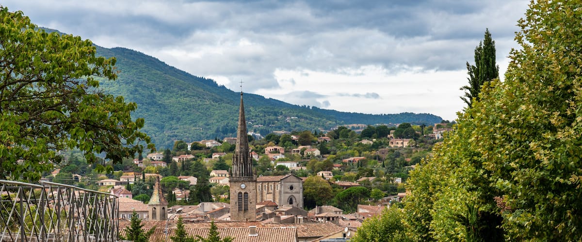 A town with a prominent church, rolling hills, and a clear road.