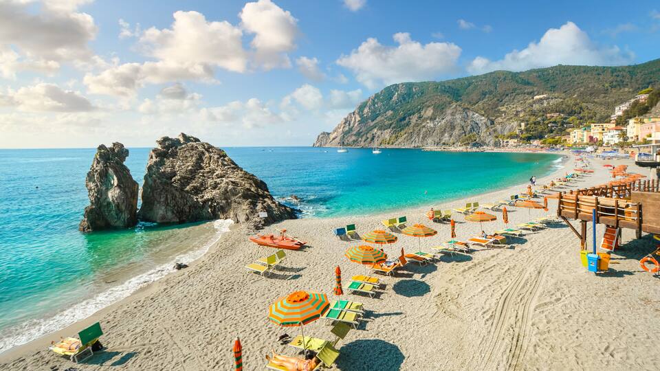 Chairs and umbrellas fill the Spiaggia di Fegina, the wide sandy beach in front of the old section of the village of Monterosso al Mare, Italy