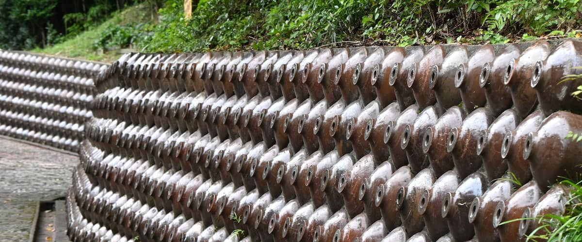 A series of cylindrical metal barriers arranged in a stepped pattern along a pathway.
