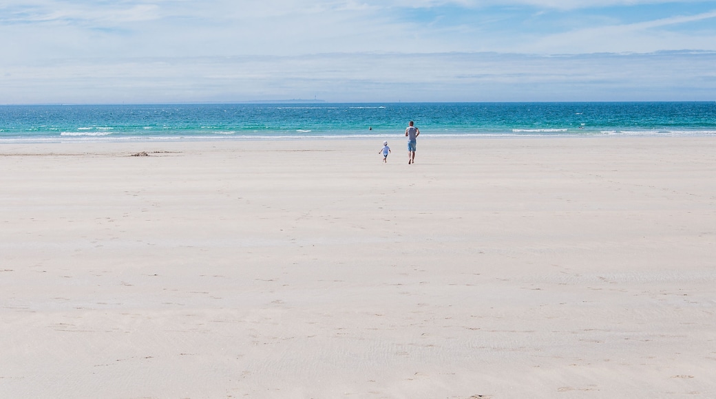 Father and son running towards the Atlantic Ocean on the beach in Finistere France