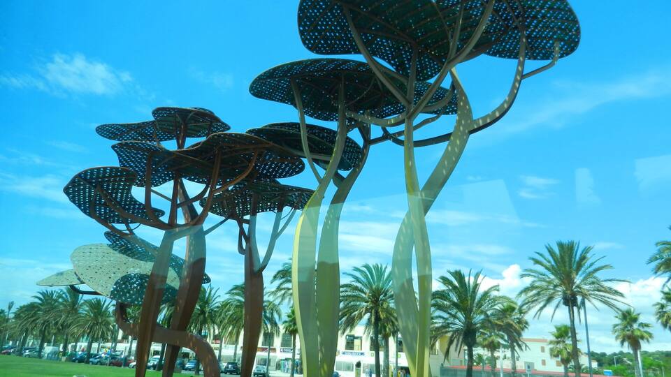 A sculpture of abstract trees with large, perforated leaves.
