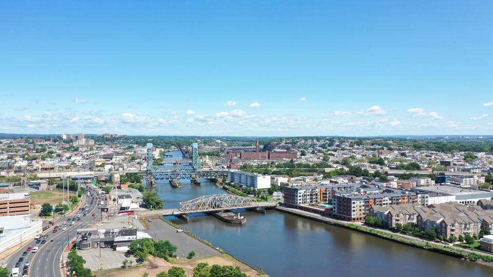 A cityscape with a river, a bridge, and a highway.