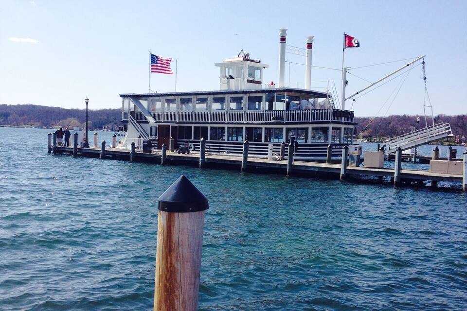 A riverboat docked at a pier with an American flag and a Turkish flag.
