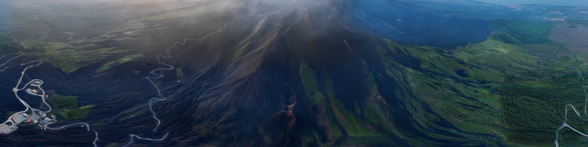 A volcano with a clear sky and a sunset.