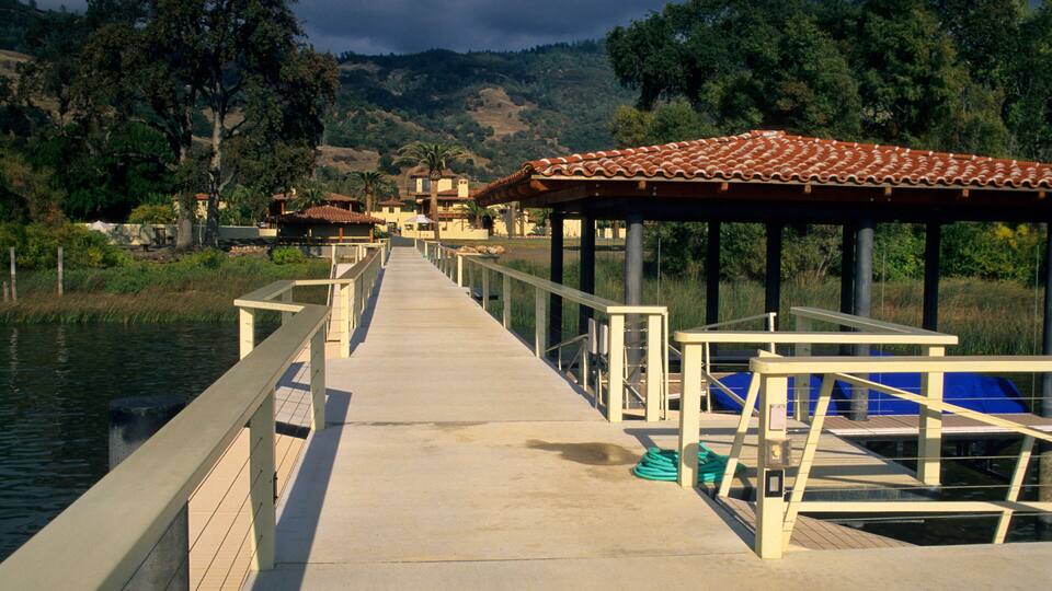 A concrete pier extending into a body of water, with a tiled roofed structure at the end.