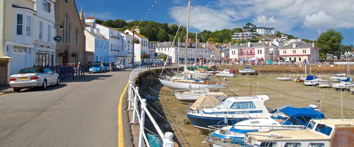 A coastal town with a harbor filled with boats, a church, and buildings along the waterfront.