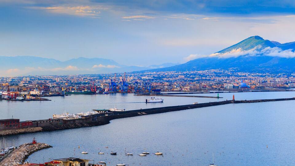 A coastal city with a prominent mountain in the background.