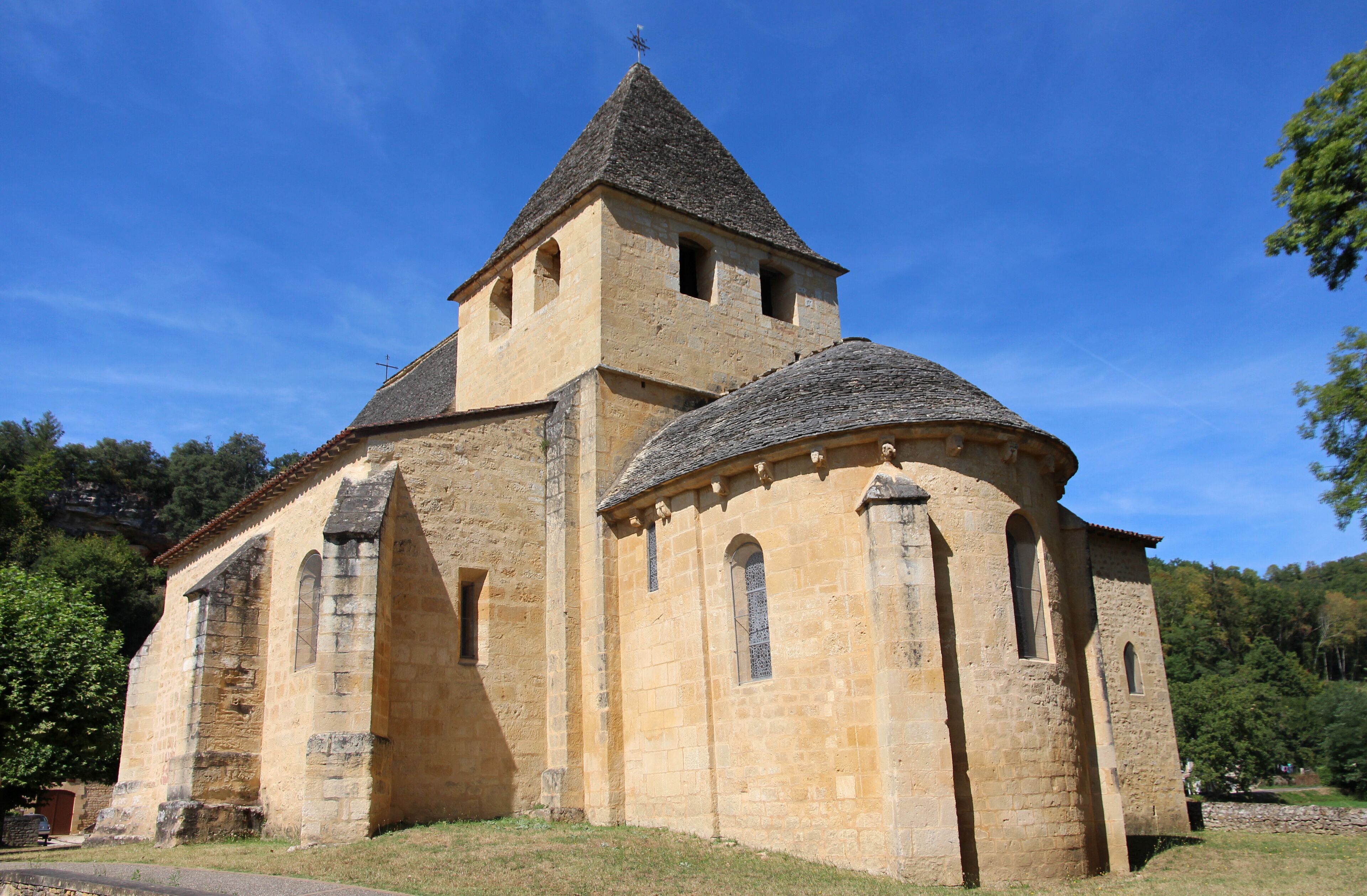A historic stone church with a bell tower and a dome.