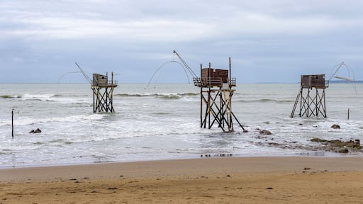 Panoramic view of three typical carrelet fishing huts on a beach in Saint-Michel-Chef-Chef, Loire-Atlantique department, western France.