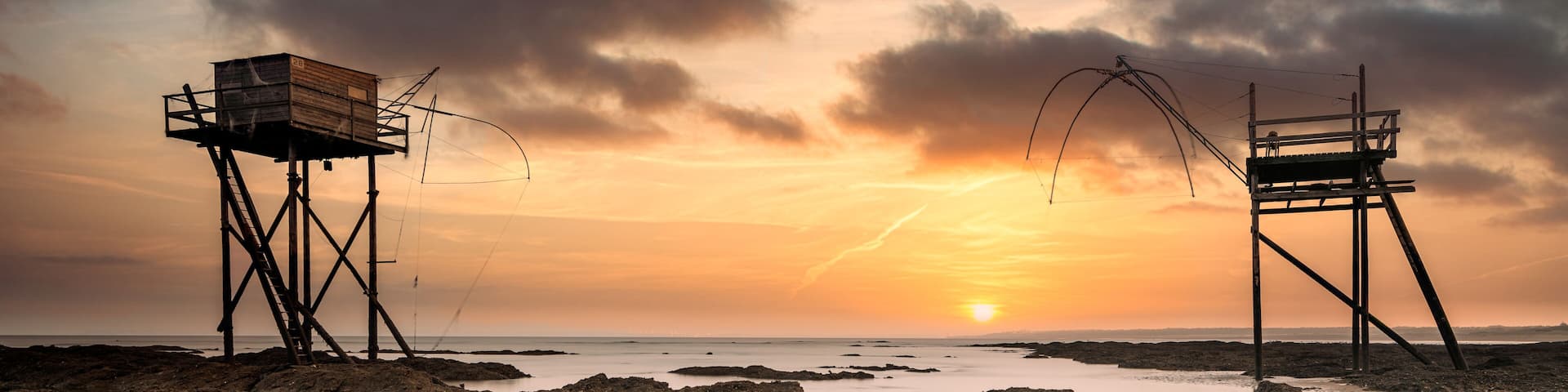 Fishing huts on beach at low tide at sunset, Saint-Michel-Chef-Chef, Loire-Atlantique, France