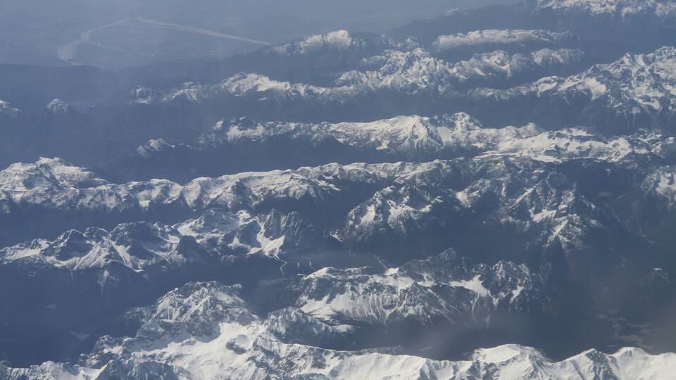 A range of snow-covered mountains with rugged peaks and valleys.