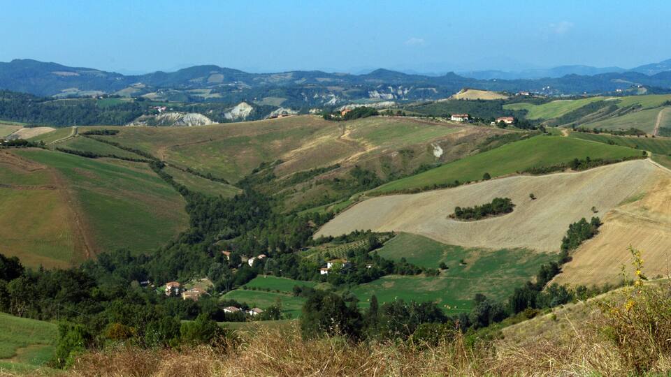 Rolling hills, a valley, and distant mountains.