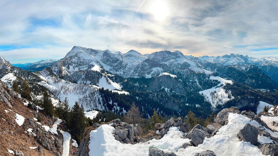 A snow-covered mountain range with a lake in the valley.