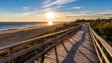 France, Nouvelle-Aquitaine, Le Bois-Plage-en-Re, Panoramic view of empty beachside boardwalk at sunset