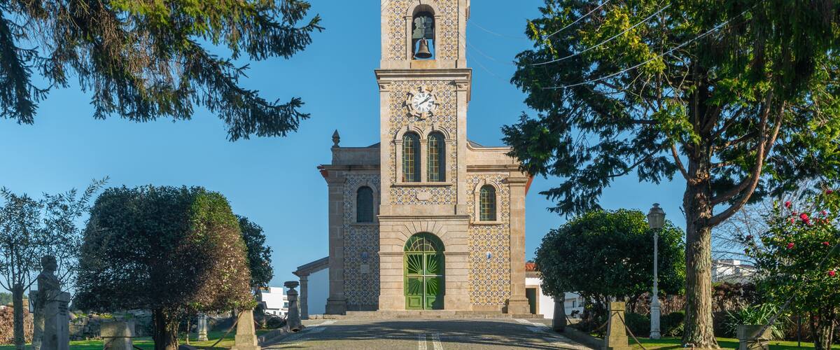 A church with a tall bell tower, green door, and a clock.