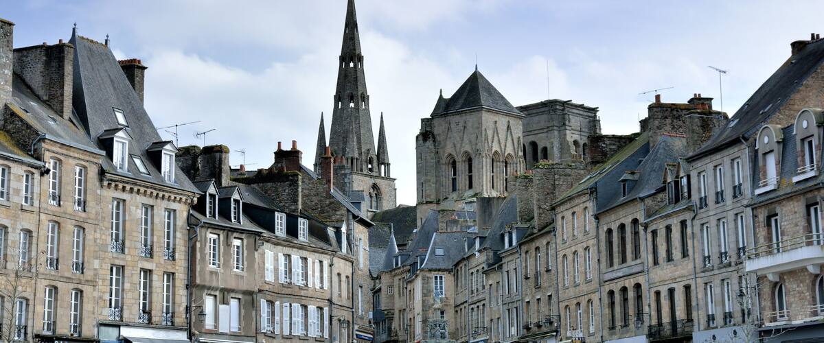 A historic European town with a prominent church spire and stone buildings.