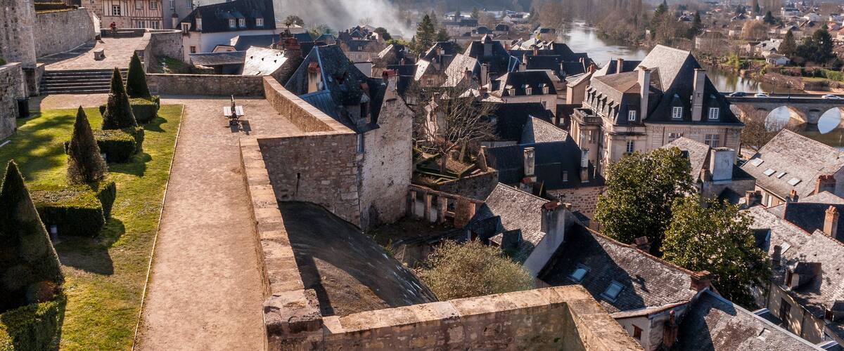 A historic town with a castle, cobblestone streets, and a river.
