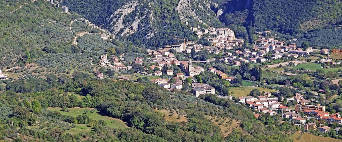 A mountainous village with terraced houses and a prominent church.