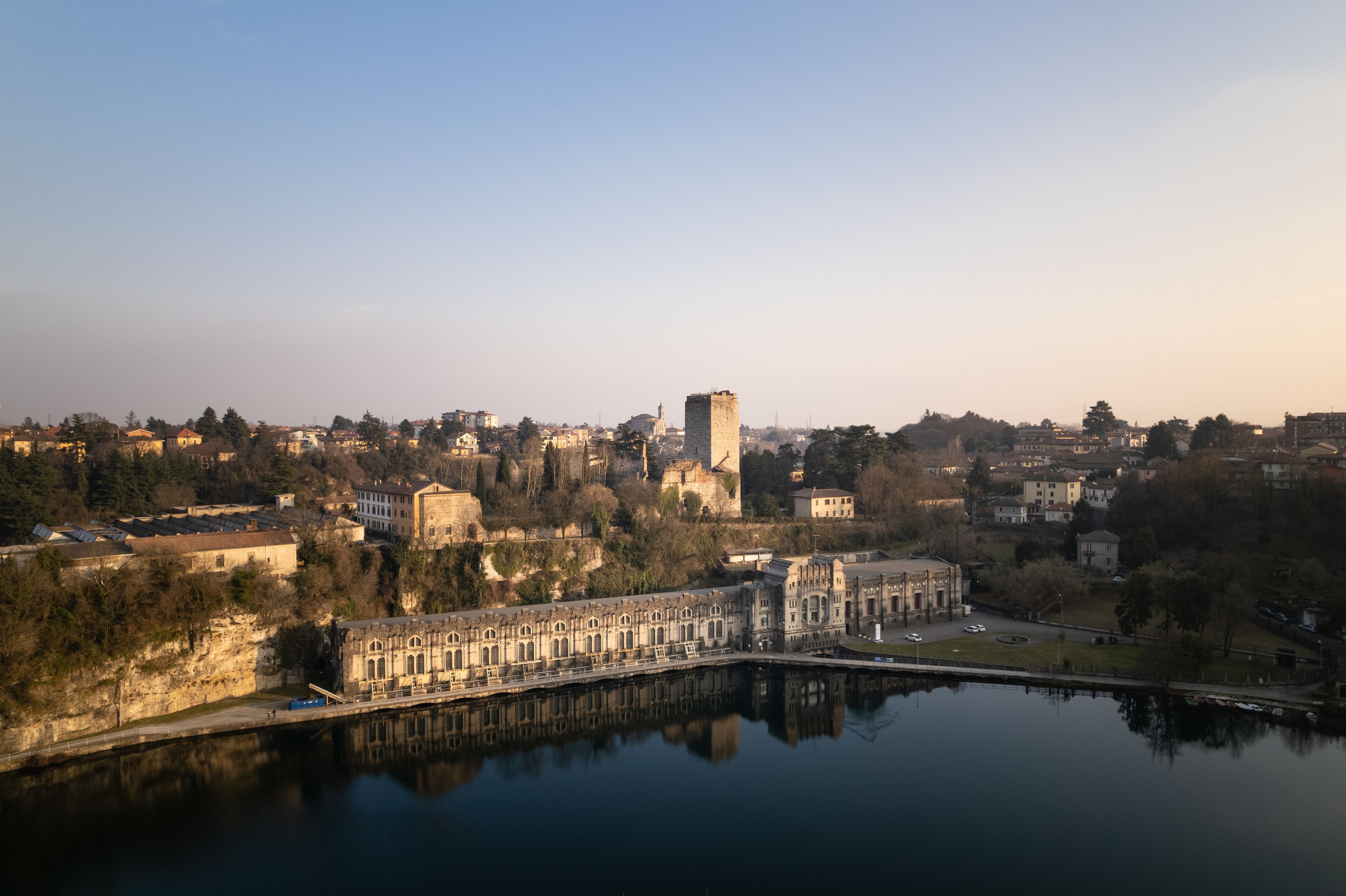 Aerial view over the city of Trezzo sull'Adda with the hydroelectric power plant in the foreground with the castle behind it.