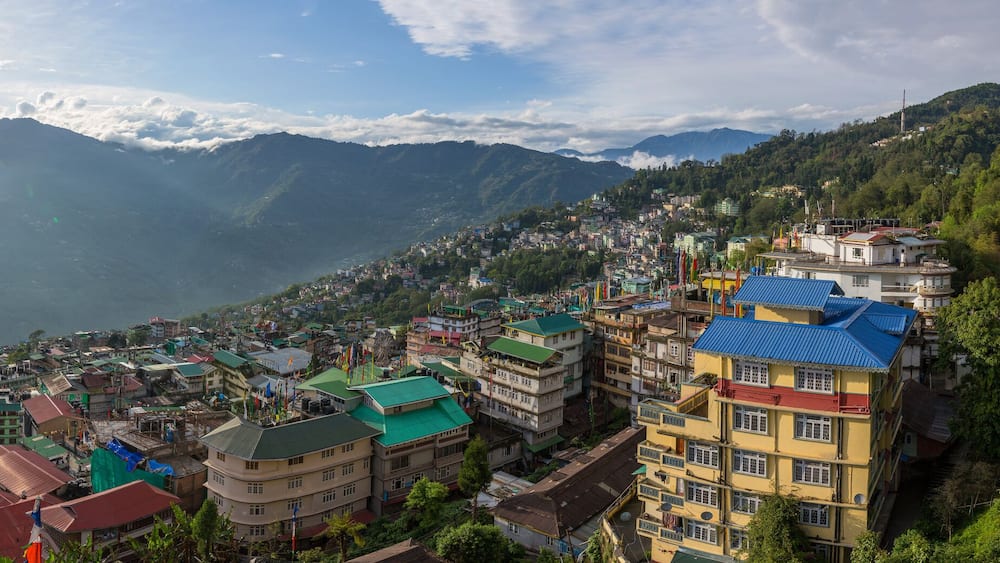 Une ville de montagne aux bâtiments aux couleurs vives, située au-dessus d’une vallée.