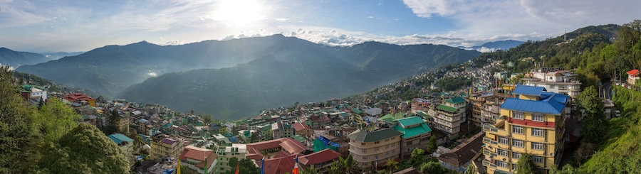 A mountainous town with colorful buildings and a valley below.