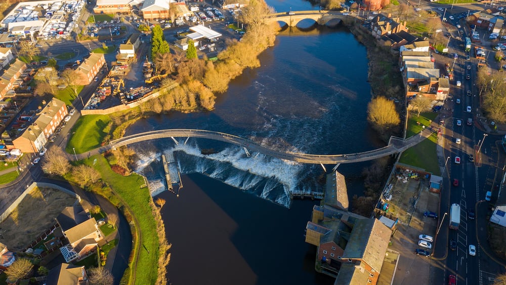 Aerial photo of the village centre of Castleford in Wakefield, West Yorkshire, England showing the main street along side the River Aire on a sunny day in the Autumn time