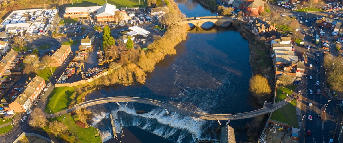 Aerial photo of the village centre of Castleford in Wakefield, West Yorkshire, England showing the main street along side the River Aire on a sunny day in the Autumn time