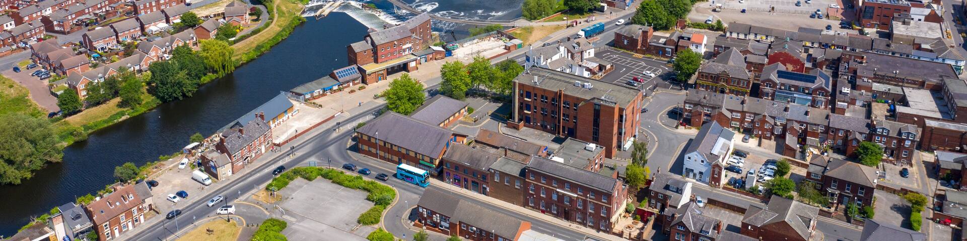 Aerial photo of the village centre of Castleford in Wakefield, West Yorkshire, England showing the main street along side the River Aire on a bright sunny summers day