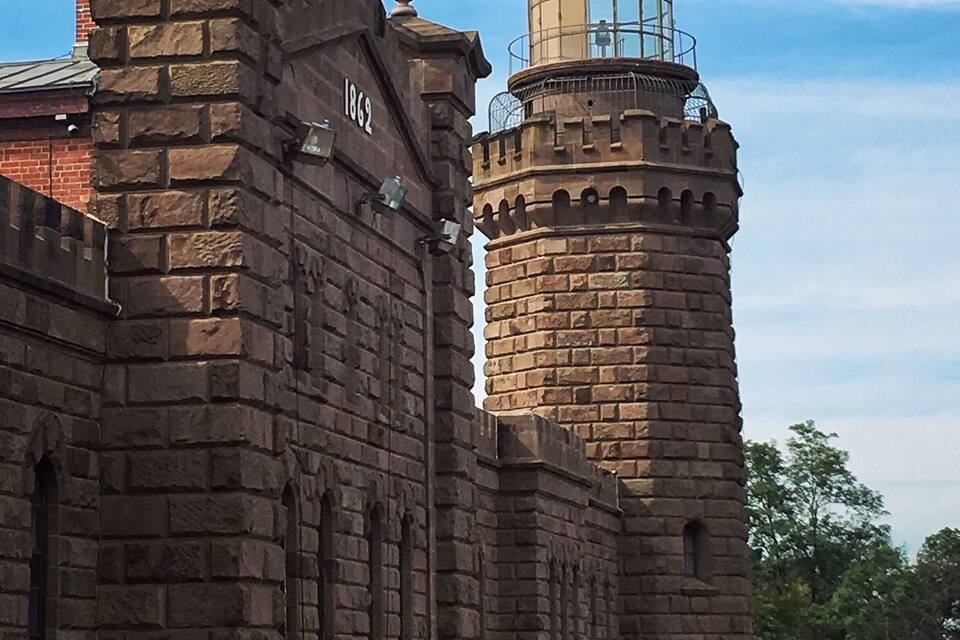 Um edifício histórico de pedra com uma torre marcada