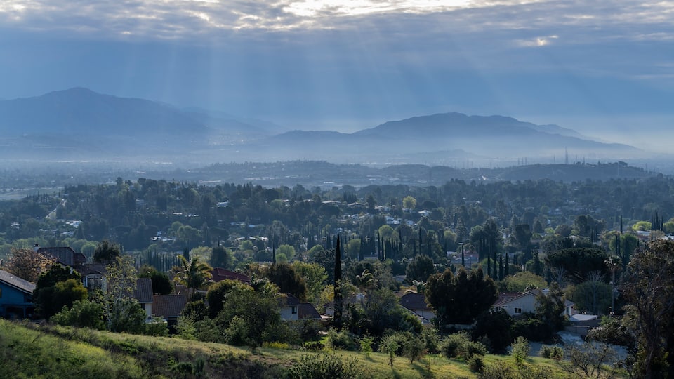 A town nestled in a valley with mountains in the background.