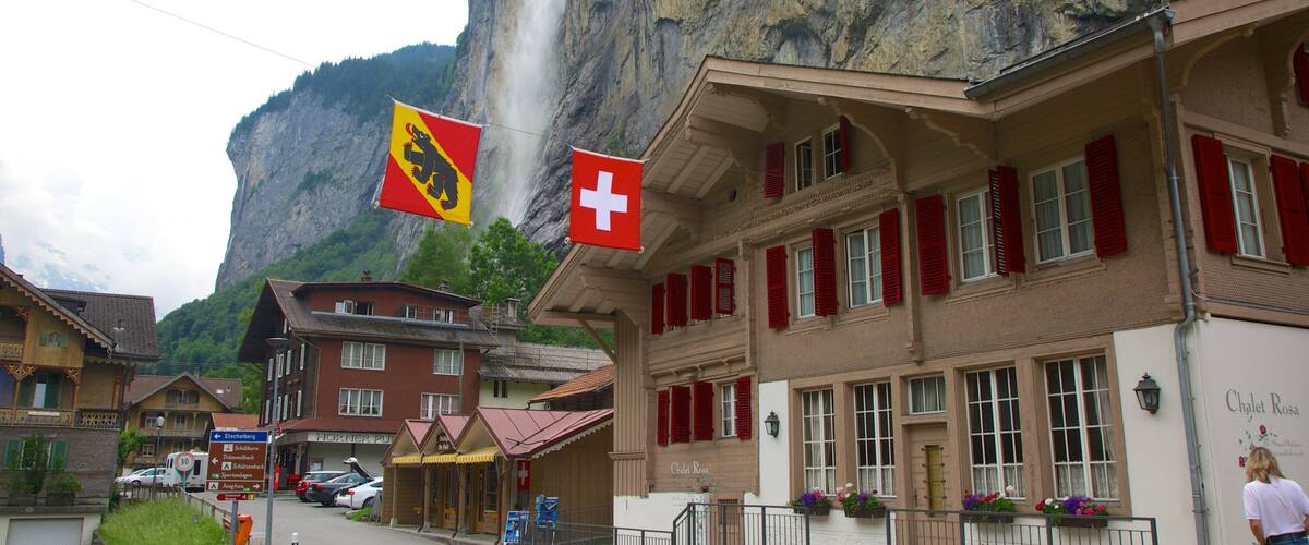 A street with buildings, a flag, and a mountain.