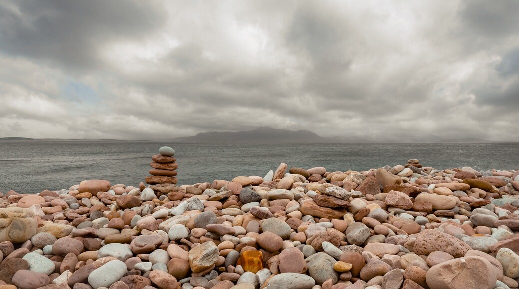 Pile of pink rocks on Mulranny Beach, county Mayo, Ireland, low cloudy sky, Croagh Patrick in the background. Irish landscape. Nobody