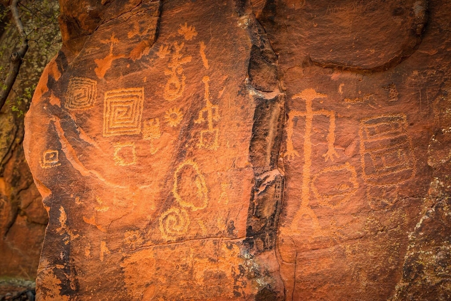 Una roca con antiguas petroglyfos, incluyendo formas geométricas y símbolos.