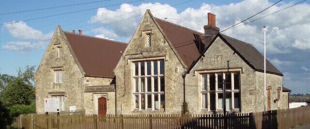 A stone building with a brown roof and large windows.