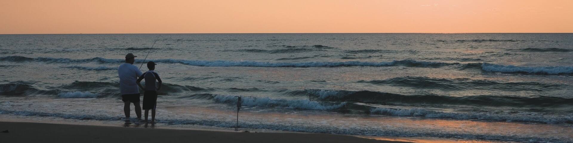 South Padre Island featuring a sandy beach, fishing and a sunset