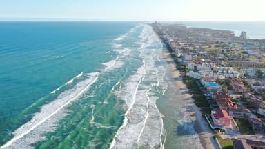 A coastal city with a beach and residential buildings along the shoreline.