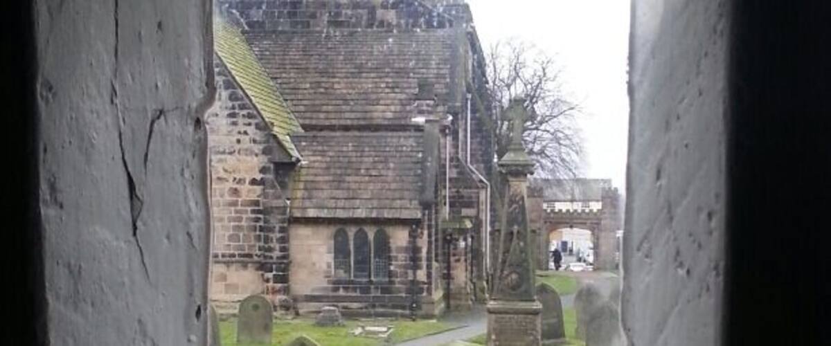 A cemetery with stone headstones and a church in the background.