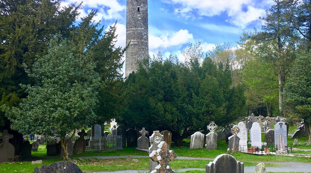 Glendalough is home to one of the most important monastic sites in Ireland. This Christian monastic settlement was founded in the 6th century. Most of the buildings that survive today date from the 10th through 12th centuries, despite attacks by Vikings over the years.
The round tower in the background was built between the year 900 and 1200 AD. It is 100 ft high and had six floors. The entry door is almost 12 feet off the ground and was presumably reached by means of a movable ladder which those inside could pull up after them to prevent an enemy from entering. Round towers were the bell towers of early monasteries and were used to summon monks to prayer. #History