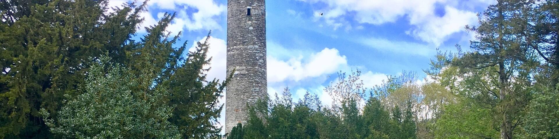 A cemetery with gravestones and a tall stone tower.